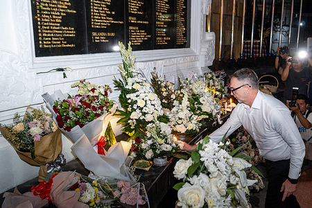 People seen placing wreaths and candles during a memorial service. People gathered to commemorate the 23rd anniversary of the Bali Bombing at the Ground Zero Monument in Legian. The coordinated bomb attacks killed 202 people including 88 Australians, 38 Indonesians and injured 209 others marking the deadliest terrorist incident in history.