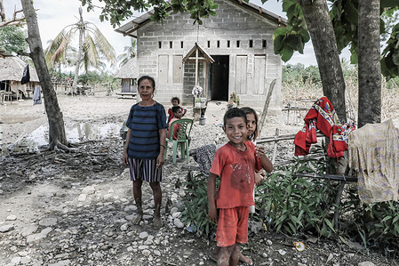 A women and her children stand in front of their house during the aftermath of flash floods and landslides that hit several areas in East Nusa Tenggara.
According to data from the National Disaster Management Agency (BNPB), the number of fatalities due to flash floods triggered by Seroja Tropical Cyclone that occurred on April 4, 2021 reached 181 people.