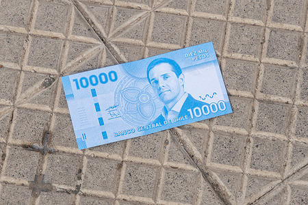 A view of a paper with the design of the $10,000 national bill with the face of Michael Clark. Michael Clark, manager of Sartor Finance Group and former president of Azul Azul, appeared before the 4th Local Police Court at the Santiago Justice Center on August 3, 2026, in connection with alleged economic crimes in the "Sartor Case," including fraud, money laundering, and providing false market information. Upon leaving the court, Clark was confronted by Universidad de Chile fans who threw imitation banknotes bearing his face in a symbolic protest against the executive and alleged corporate misconduct.