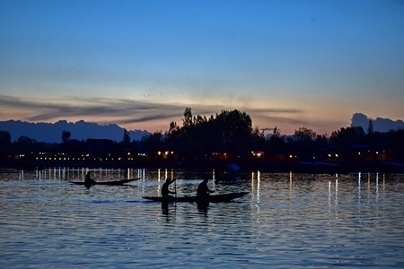 Boatmen are seen rowing their boats on the waters of Dal Lake during a spring day in Srinagar.