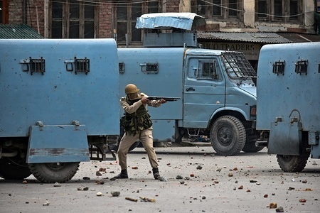 An Indian policeman aims his pellet gun towards Kashmiri protesters ( not pictured) during clashes in Srinagar, Indian administered Kashmir. A large number of protesters took part in a rally in Srinagar, the largest city of the disputed Himalayan valley, following Friday prayers, and demanded an end to the Israeli occupation of Palestinian land. The mass rally turned violent after police fired teargas, pellets and rubber bullets to disperse the protesters in Srinagar. The angry demonstrators chanted pro-Palestinian slogans and anti-Indian slogans. They also urged international community to take serious steps to halt the Israeli aggressive policies and its expansionist agenda. Nearly, 60 Palestinians were killed by live gunfire and over 1,359 were wounded last week in the ongoing Israel military operations in the Gaza Strip.