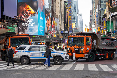 NYPD cars and NYC Sanitation trucks block access to cars to protect protesters as the march down 7th Avenue during a "No Kings" protest in Manhattan on March 28, 2026 in New York City.