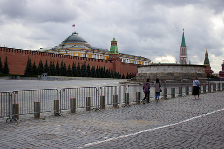 Tourists walk along a police fence blocking the Red Square in Moscow the day after the head of the Russian private military company "Wagner," Yevgeny Prigozhin, died in a plane crash. The crash sparked various theories about who was responsible for Prigozhin's death. He was a person who had staged a short-lived military coup in Russia two months prior. In an odd coincidence, Prigozhin's business jet was downed on the same date that his private military group had rebelled.