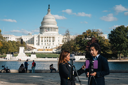 International reporters cover US election news in front of the barricaded Capitol in Washington. Washington DC braces itself for civil unrest in the days and potentially weeks following the election, It comes after a mob of Trump supporters stormed the Capitol on January 6, 2021, as they sought to stop Congress from counting electoral college votes.