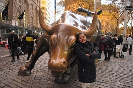 A person takes photos by the "Charging Bull" statue in the Financial District in Manhattan, New York City.