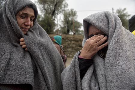 Two asylum-seekers cry as they explain they cannot locate a missing relative. They were outside Moria Camp during a period when hundreds of migrants were made to wait under cold rain in order to register after arriving in Greece. In 2015 more than a million immigrants arrived in Europe by sea. 
The immigrants are mainly refugees who are escaping the war in Syria.
