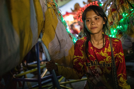 A girl performs the Lion Dance in Chinatown during Chinese New Year. Chinese New Year in Chiang Mai's Chinatown is a lively affair with red decorations, lion dances, and fireworks. The area around Warorot Market fills with food stalls, traditional performances, and communal festivities, celebrating the New Year with joy and cultural flair.