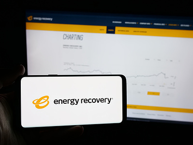 In this photo illustration, a person is holding a smartphone with the logo of US refrigeration company Energy Recovery Inc. on screen in front of website.