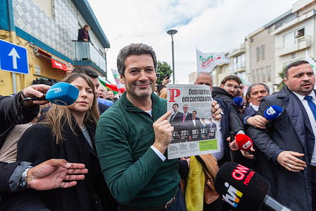 Presidential candidate André Ventura holds up the day’s edition of Público, displaying the latest poll where he appears in first place with 24% of voter intentions, ahead of rivals, during a campaign rally in Vila do Conde.