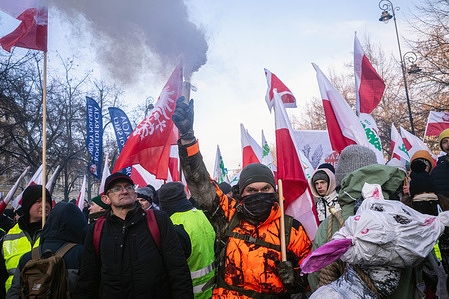 A protester holds a smoke flare during the demonstration. On the morning of 9th January 2026, farmers gather in Warsaw to protest the signing of the agreement between the European Union and the Mercosur countries. Protesters carry placards, flags, and banners, and lit flares and bangers along the route. Though representatives from France, Hungary, Ireland, Austria, and Poland voted against the measure, the member states of the EU voted for the agreement during the time the protest moved through the streets.