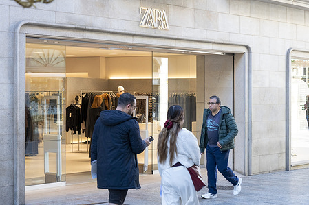 Pedestrians and shoppers walk past the Spanish multinational clothing design retail company by Inditex, Zara, a store in Spain.
