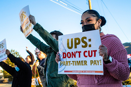 A protester holds a placard that says "UPS: Don't cut part-timer pay" during the demonstration. 
United Parcel Service (UPS) employees and supporters gathered to protest wage cuts for part-time employees.