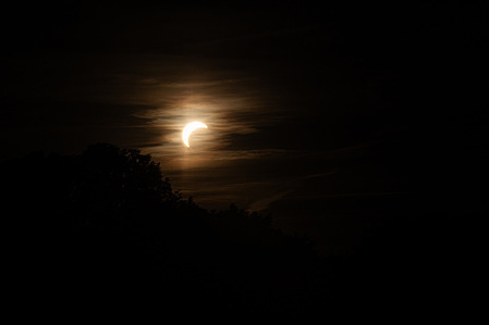 The Moon begins to cover the Sun during a partial solar eclipse, seen through clouds over Leipzig. Residents gathered in the evening to observe the Moon move across the face of the Sun. The eclipse began at 7:17 p.m. CEST and reached its maximum over the city at 8:10 p.m.