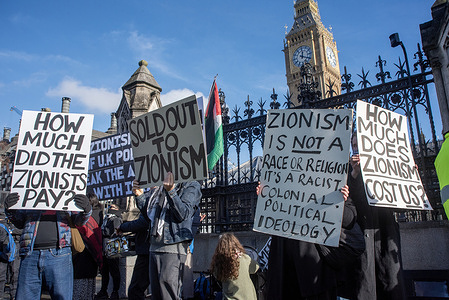 Protesters hold placards expressing their opinion in front of Big Ben during the demonstration. A small group of Pro-Palestine activists gathered outside the Parliament in London to demand the release of members of the hunger strike which were proscribed as terrorist organisation, also to take it off from the terrorist list.