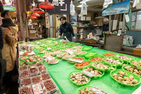A seafood vendor prepares and sells fresh shellfish and seafood to customers at Omicho Market in Kanazawa, Japan. Known as “Kanazawa’s Kitchen,” the market has operated since the Edo period and is a major destination for fresh regional seafood and local cuisine.