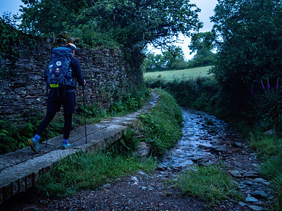 A hiker is seen walking during the sunrise on a stone pavement. The Camino de Santiago (also known as the St James Way) is a large network of ancient pilgrim routes stretching across Europe and coming together at the tomb of St. James (Santiago in Spanish) in Santiago de Compostela in northwest Spain. The Camino Primitivo is the original and oldest pilgrimage route. It links Oviedo with Santiago de Compostela. It's characterized as being one of the hard routes. In 2015, it was listed as a World Heritage Site by UNESCO, along with the Northern Route.
