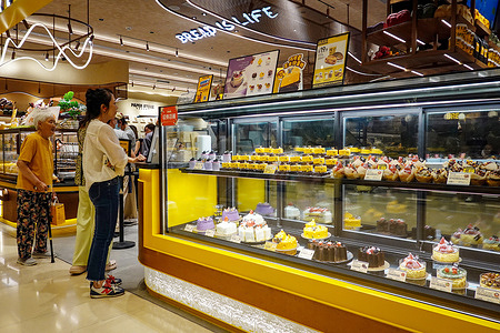 At a bakery counter with the sign "Bread is life" People queue to buy cakes and pastries on display. NBS (National Bureau of Statistics of China) data shows retail sales in China rose 5 percent year-on-year in the first half of 2025, up from 4.6 percent in the first quarter.