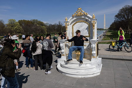 A man poses for a photo with a gold-painted, faux-marble toilet statue titled ìA Throne Fit For A Kingî, which is installed near the Lincoln Memorial on the National Mall. The satirical installation references reports of renovations to the bathroom connected to the Lincoln Bedroom at the White House during former President Donald Trumpís tenure. The unexpected display drew attention from visitors and sightseers.