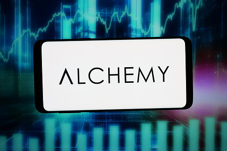 In this photo illustration, the logo of Canadian nanotechnology company Alchemy Nano is seen displayed on a smartphone in front of an abstract background on a computer screen.