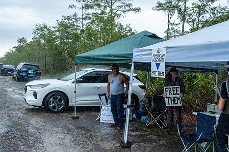 Protesters line the street outside the entrance to the immigration detention facility in the Florida Everglades known as "Alligator Alcatraz", in Ochopee, Fla. On August 21, 2008, a federal judge ruled that no new prisoners could be sent to the center and much of the facility would need to be dismantled within 60 days after finding that the government did not conduct environmental assessments before building.