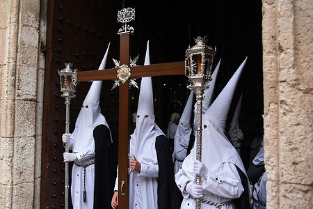 The Nazarenes of the Brotherhood of the Sorrows of El Vendrell with hoods and the Cross leave the church during the Palm Sunday Procession. The Brotherhood of Sorrows of El Vendrell celebrates the Palm Sunday procession during the Easter holy week. The religious images of the Virgin of Consolation and Jesus of Sorrows will be shown off during the parade around Vendrell.