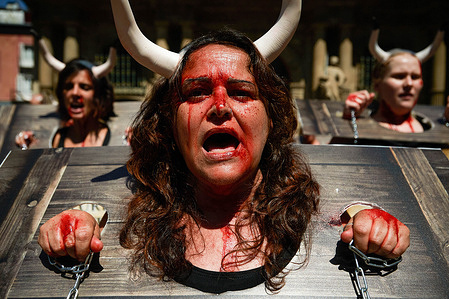 A protester stained with fake blood and chains on her wrists takes part during the demonstration. A protest against bullfights was held before the San Fermín 2024 festivities. At noon, representatives of PETA and ANIMANATURALIS groups in defense of animals gathered at the Plaza Consistorial of the city of Pamplona in their underwear, carrying bull horns, splattered with blood in chains and with pieces of cardboard simulating a bull in a fence. They carried placard with the slogan 'Pamplona: violence and death against bulls' in different languages. They also denounced bullfighting as medieval torture.