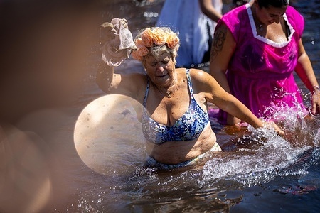 An old woman seen having a traditional Holy Bath that concludes the São Bartolomeu Paper Costume Parade in Foz do Douro. People showcased handcrafted paper costumes created by local associations, schools and community groups as part of one of the region’s most emblematic cultural traditions.