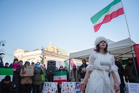 A female protester in a white dress stands under the Iranian flag during the demonstration. A ‘Free Iran’ solidarity demonstration was held in Warsaw in connection with nationwide protests in Iran. Iranians are protesting against the Islamic regime. Protesters face bullets, mass arrests and state terror. The regime has imposed an almost complete communication blockade. Iranians speak with one voice: regime change, free and democratic elections, closure of the Islamic regime's embassies, expulsion of individuals and organisations that whitewash the regime's crimes. Iranians in Iran are dying without a voice. The demonstration in Warsaw aims to make this voice impossible to ignore.