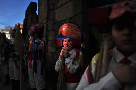 Chocalerios marching through the streets during the parade.
Vilardevos parade is a typical carnival of Galicia, a small town located in the province of Orense, that celebrates carnivals in an ancestral way, chocaleiros (participants) parade through the streets dressed in masks and colourful costumes, sounding their cowbells, called "chocas", touring the town to the sound of music and bands with large drums making all the neighbours rumble.