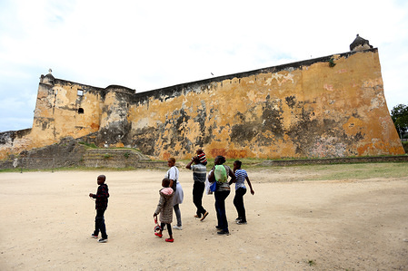 Kids seen walking close to a section of Fort Jesus.
Fort Jesus in Mombasa, Kenya was built is 1593-1596 by the Portuguese, as an early attempt of colonization in East Africa. Local leaders in Mombasa sought support from Omani Arab authority to expel Portuguese from Mombasa who captured Fort Jesus after about three years of battle with the Portuguese. Between the year 1895 and 1968 the government converted it to a prison. Later in 1960, A Museum was built and the Fort was opened to the public as an historical monument.