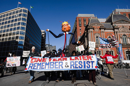 Demonstrators hold a sign reading ìOne Year Later Remember & Resistî during a protest against policies of U.S. President Donald Trump near the White House. Protests were held across the United States marking one year since President Trump began his second term.