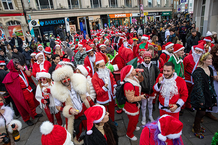 Santa's seen during the Santa-Con London. Dozens of individuals dressed as Santa Claus participated in the annual Santa-Con London. The event began with participants assembling at Tower Hill at 1200, followed by a procession through the City of London, including several stops at various pubs and bars. The activities concluded with a major gathering at Trafalgar Square.