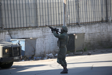 An Israeli soldier fires his weapon during a military operation around the old city. Israeli forces raided the old city stormed Palestinian homes and searched for weapons and other military equipment. Four Palestinians were wounded by gunfire and two were arrested during the operation.