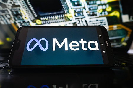 In this photo illustration, a Meta logo is seen displayed on a smartphone with electronic components on the background.