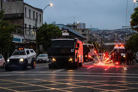 Police receive a firework during a march commemorating the sixth anniversary of the social outbreak. March commemorating the sixth anniversary of the social uprising that began.
