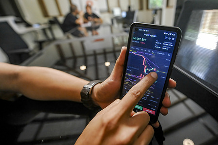 A man holds a cellphone displaying an application that shows the price of Bitcoin.
Salvadoran President Nayib Bukele has announced that he will propose a law to the Congress, where his party controls a majority, for Bitcoin to become legal tender. El Salvador would become the first country in the world to accept a cryptocurrency as a legal tender.