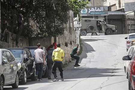 Palestinians confront Israeli forces with stones in the Old City of Nablus during a security operation. Israeli forces raided the market, targeting shops. Dozens of Palestinians were arrested in West Bank cities under the control of the Palestinian Authority, headed by President Mahmoud Abbas.
