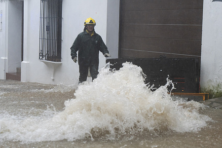 An INFOCA firefighter seen working amidst flooding caused by Storm Leonardo. The southern Spanish region of Andalusia has borne the brunt of Storm Leonardo with regional authorities declaring a red alert after torrential rainfall triggered flooding and caused rivers to burst their banks.
Emergency services were placed on high alert across the region which is home to around 8.5 million people as heavy downpours inundated low-lying areas and forced road closures. Authorities urged residents to remain indoors and follow official guidance as the risk of further flooding persisted.