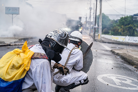 Two protesters hide behind a shield in confrontation with police during a protest in Popayan.
Protesters confront police in protest of the assassination of Esteban Mosquera, a student leader and anti-police brutality activist in Popayán. The protest is part of an on-going national strike that began in Colombia on April 28th in reaction to tax reforms that would target the poorest in the country.