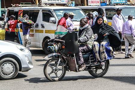 A man carries a woman on the back of his motorcycle through a street in Nakuru. Kenya’s inflation rate remained unchanged at 3.8% in June 2025, despite persistently high costs of food, transport, and housing.
