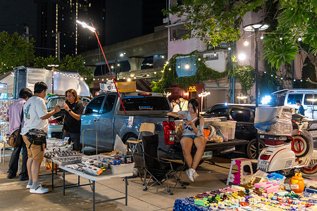 A couple is seen selling toys in front of their car, at The Green Vintage Market in Ratchayothin, Bangkok. The Green Vintage Market in Ratchayothin, Bangkok, is an outdoor market known for its eclectic mix of vintage goods and handicrafts. With its bohemian atmosphere, the market also features a section specializing in vintage and collectible toys, where toy collectors and enthusiasts can find rare action figures, model cars, classic dolls, anime figurines, and other nostalgic treasures.
