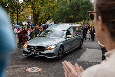 A hearse drives down Daniher way during the Guard of Honour for Neale Daniher's state funeral. Neale Daniher, a revered figure in Australian sport and a leading advocate in the fight against motor neuron disease, is honored with a state funeral following his death at the age of 64.