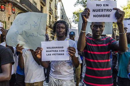 Street vendors of Barcelona march in solidarity for the victims of the terrorist attack in Barcelona. Young sellers raises a sign with the text "solidarity with the victims"