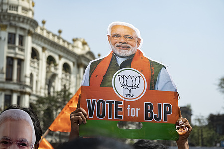 BJP supporter holds a placard with a portrait of Narendra Modi during a mass rally.
Bharatiya Janata Party (BJP) supporters held a mass rally and political campaign ahead of the state legislative assembly elections at the Brigade Parade ground in Kolkata. India's Prime Minster Narendra Modi also joined the campaign.