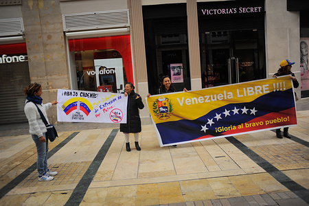 Venezuelan protesters hold banners as they take part in a protest against the Nicolás Maduro government at Marqués de Larios street in downtown Málaga.