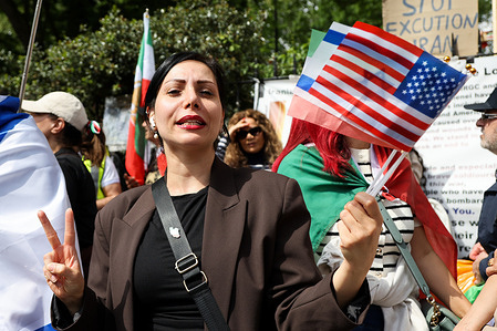 An Iranian anti-government demonstrator and a supporter of exiled Crown Prince, Reza Pahlavi seen holding US flag during a protest outside the Embassy of The Islamic Republic of Iran .