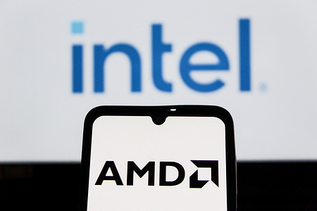 In this photo illustration, the AMD (Advanced Micro Devices) logo is seen displayed on a smartphone screen with an Intel logo in the background.