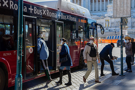 People wearing face masks as a preventive measure get off and on a bus in Piazza Venezia.In Italy, the increase in coronavirus is over 10,000 a day and has prompted the government to oblige protective masks on the streets and to take other measures to contain the pandemic.