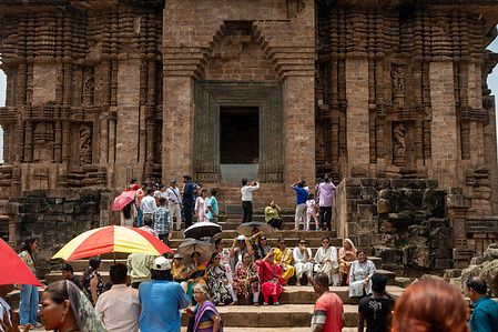 Visitors sit in front of the main structure of the Konark Sun Temple while posing for photographs, as others use mobile phones to take pictures in Konark, Puri. Konark Sun Temple is one of India’s most spectacular historical monuments and is a UNESCO World Heritage Site. The temple was built in the 13th century, around 1250 CE, during the reign of King Narasimhadeva I of the Eastern Ganga dynasty. The Konark Sun Temple was designed as a gigantic stone chariot of the Sun God, pulled by seven horses. The chariot has 24 enormous, beautifully carved stone wheels. The temple is a remarkable example of Kalinga architecture. The original temple complex was much larger than what survives today. Over time, the main sanctum and its towering structure largely collapsed, but the surviving Jagamohana, or assembly hall, along with other structures, still displays extraordinary stone craftsmanship from that era.
