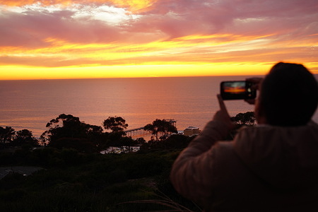 A man takes photos of the sunset at the coastline of San Diego Sunset in San Diego.